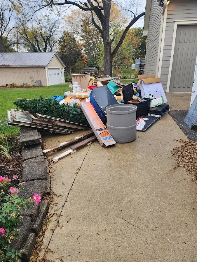 Dumpster being loaded with debris for Estate Cleanout Dumpster Rental in Basehor